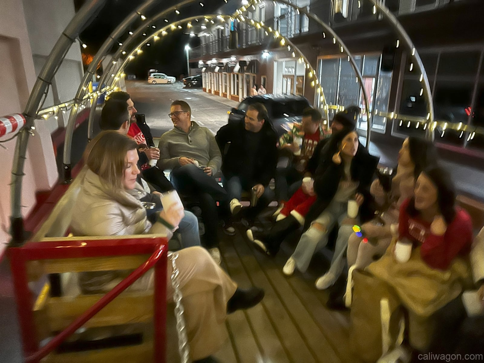 Riders aboard the Cali Wagon under lit hoops on a decorated Willow Glen street, December 2024 (photo 24 of 81)