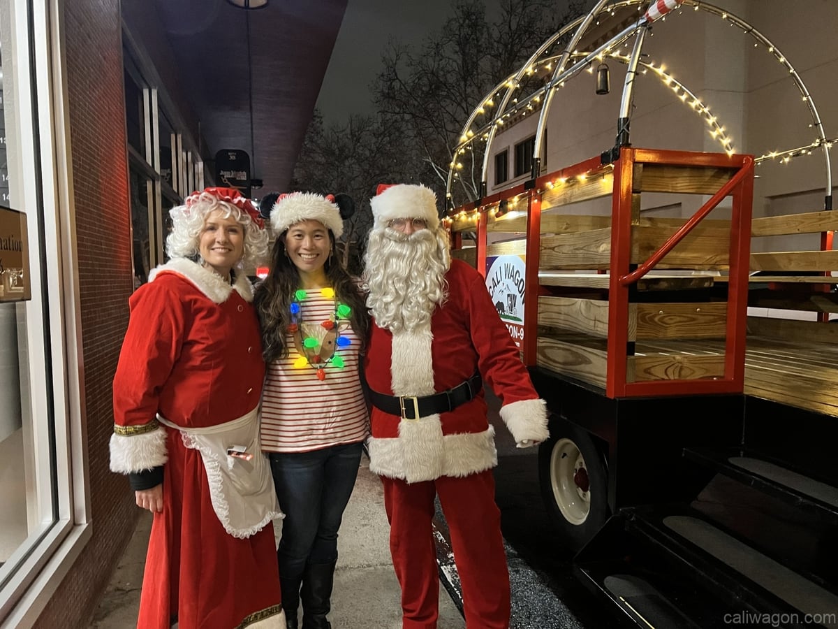 Riders aboard the Cali Wagon under lit hoops on a decorated Willow Glen street, December 2024 (photo 81 of 81)